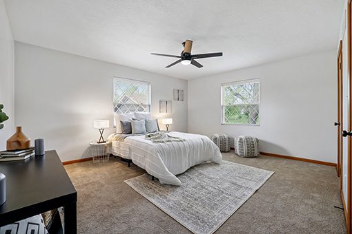 A bed with a white comforter in a clean bedroom.